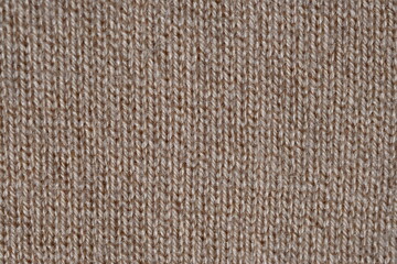 brown texture of knitted wool fabric as a background, smooth symmetrical lines of hand-knitted needlework pattern 