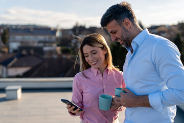 Caucasian Business Executives Enjoying Coffee Break on Rooftop with Smartphone