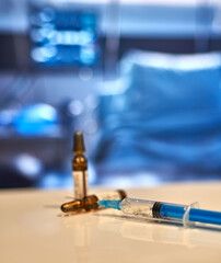 ampoules and a syringe lie on the table in a hospital ward