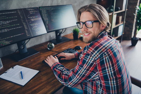 Photo of attractive young man work computer programmer dressed plaid shirt comfortable businessman startup office loft room interior