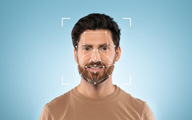 A man with a beard smiles confidently while facial recognition technology is displayed over his...