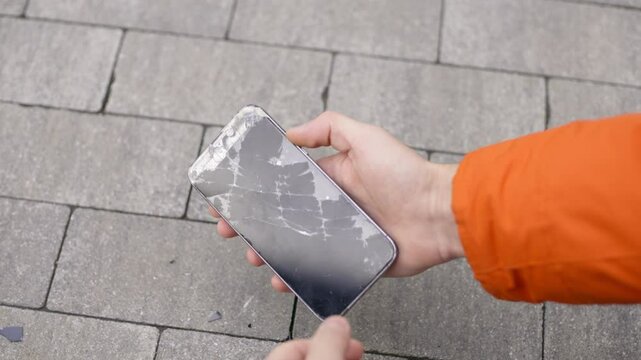 Crash smartphone on pavement and man picks it up holding a with a broken screen smartphone in his hand, Super slow motion footage 4K