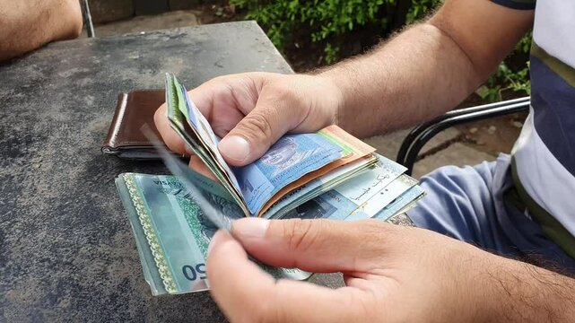 A businessman counting Malaysian Ringgit by hands. A paper currency counting manually. 