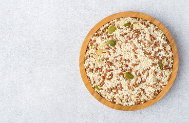 A mixture of flax, sesame, sunflower and pumpkin seeds in a wooden bowl on a light background. The concept of proper nutrition, healthy lifestyle. horizontal