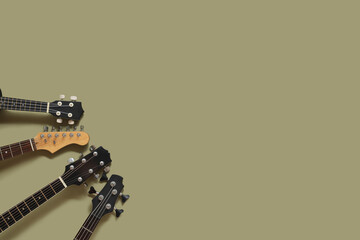 Heads of different guitars on green background