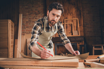 Photo of artisan guy hold blueprint write scheme production in garage indoors