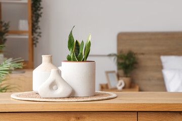 Houseplant on wooden chest of drawers in bedroom