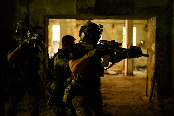 Group of soldiers with rifles in dark room liberating territory.