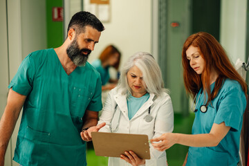 Doctors reviewing patient's chart and X-ray results in hospital.