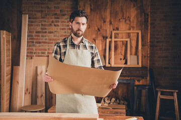 Photo of professional artisan workman hold blueprint read analyze project in garage
