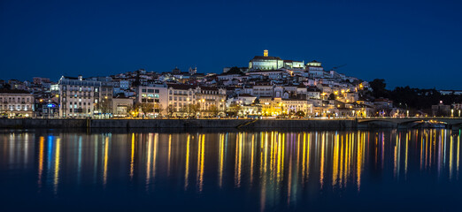 City Lights Reflecting on Water.
The tranquil reflections of city lights  (Coimbra, Portugal) on the water at night, creating a serene and peaceful atmosphere.