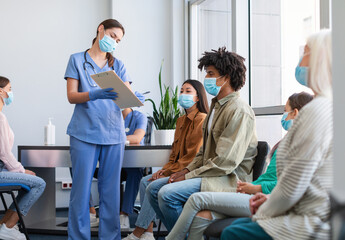 Coronavirus Vaccination Campaign Concept. Female doctor or nurse in uniform holding clipboard while...