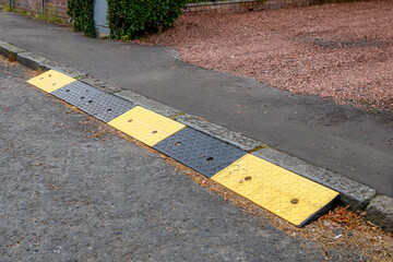 Rubber kerb ramps at end of domestic drive and pavement sidewalk to tarmac road
