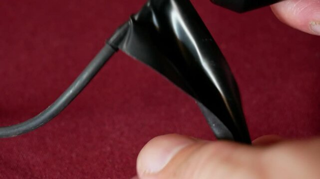 Repairing a microphone with black electrical tape close-up