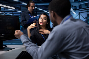 IT staff members in server room ensuring data remains shielded from potential threats. Multiracial...