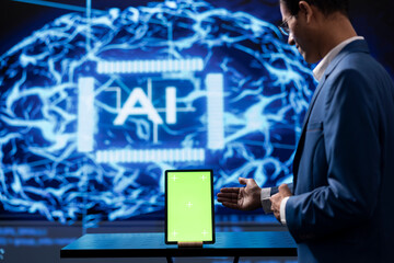 Startup employee looking over green screen tablet, using AI software to take data driven decisions....