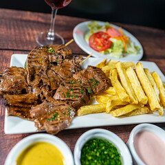heart anticucho with french fries, strawberry salad, homemade creams and a glass of wine