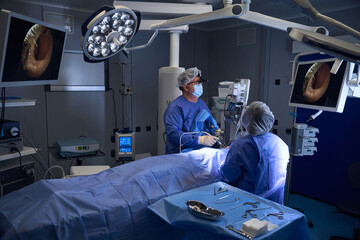 Surgeons preparing instruments during surgery in OR