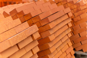 Stacks of new, red ceramic brick stacked on wooden pallets.