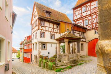 A small courtyard with stone gazebo outside the historic Hofbrunnen building built in the year 1458, in the medieval town of Rothenburg ob der Tauber, Germany.