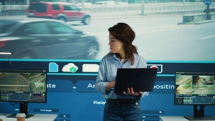 Young manager analyzing traffic surveillance data with her employees team, using the CCTV security...