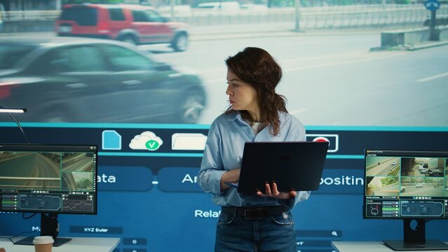 Young manager analyzing traffic surveillance data with her employees team, using the CCTV security system around the city. Agency experts employing satellite radars for reconnaissance. Camera B.