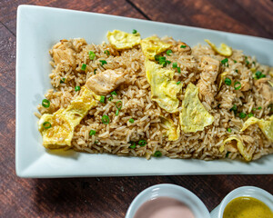chaufa rice with chicken chunks, accompanied by homemade creams