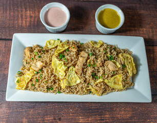chaufa rice with chicken chunks, accompanied by homemade creams