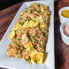 chaufa rice with chicken chunks, accompanied by homemade creams