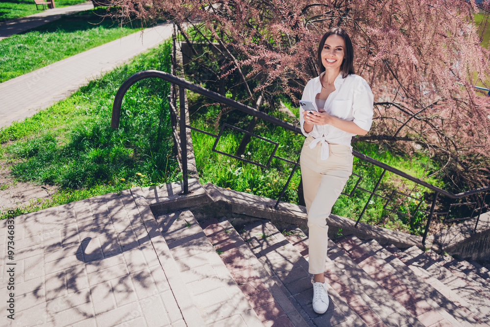 Sticker full body photo of young cheerful woman stand stairs hold device wear white outfit walk park sunny s