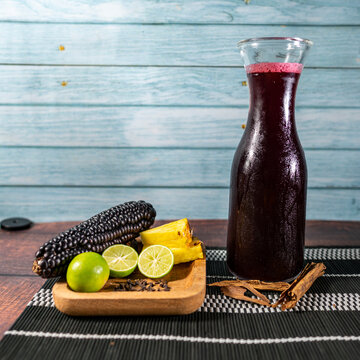pitcher of chicha morada, purple corn on the cob, lemons, pineapple and cinnamon