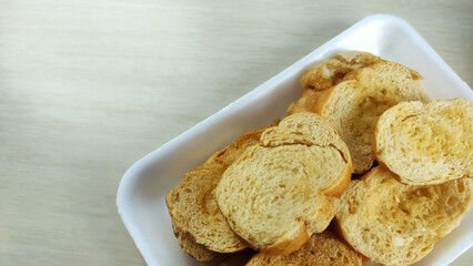  Buttered toasts made of salt french bread on the plate.
