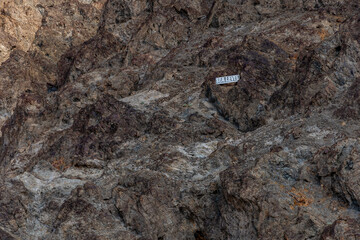 Sea level marker on the rocky cliffs above Badwater Basin in Death Valley, California, highlighting...