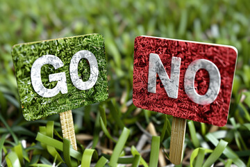 Green and Red Signs with 'Go' and 'No' on Grass
