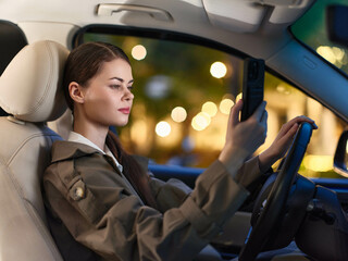 Woman driving car holding phone, looking at screen, distracted driving concept, safety risk