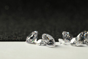 Beautiful dazzling diamonds on light grey table, closeup