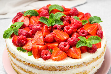 Tasty sponge cake with fresh berries and mint on table, closeup