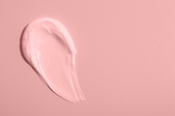 Sample of face cream on pink background, top view. Space for text