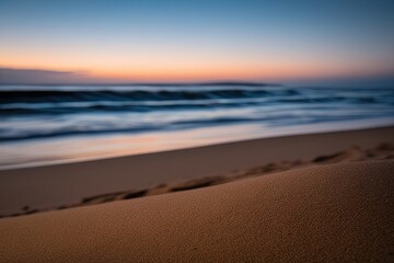 Fototapeta premium Serene Dusk Beach Scene with Warm Sand and Dark Blue Waves Reflecting Light