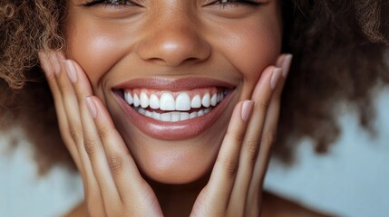 Obraz premium Close-up of a woman smiling with her hands on her face.
