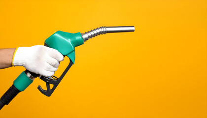Naklejka premium Hands holding green Fuel nozzle on yellow background, used in the gasoline industry