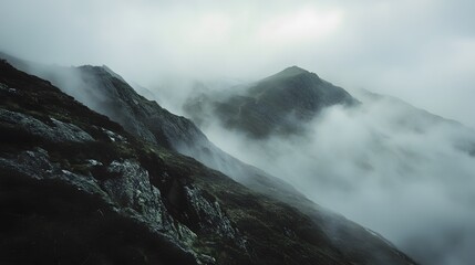 Obraz premium Misty Mountain Peaks with a Dramatic, Fog-Filled Sky