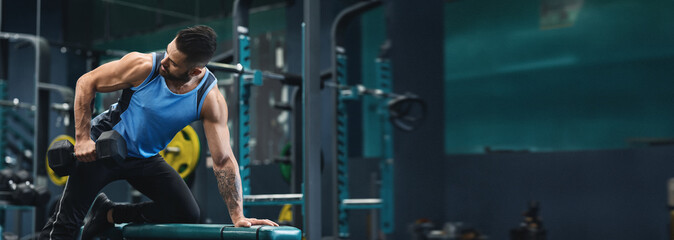 A man performs a strength training exercise with a dumbbell at a gym, focusing on building muscle...