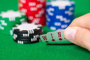 Cards, chips, gambling, poker, blackjack, hand holds cards that spell WIN
