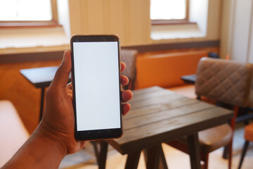 A Smartphone Display Set Against the Backdrop of a Modern Cafe Environment and Atmosphere