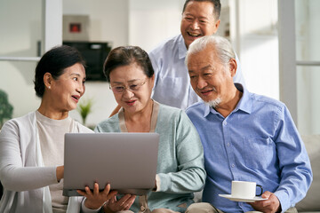 group of senior asian people using laptop computer together