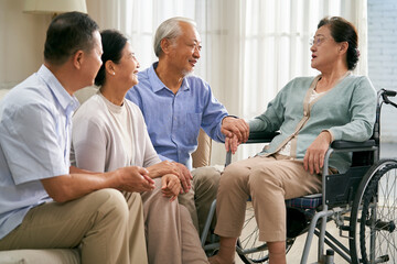 group of happy senior asian people gathering at home