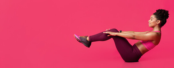 Young sporty afro woman practicing over red background doing crisscross exercise, bicycle crunches pose sitting on floor, copy space