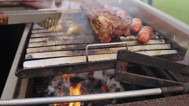 Chef grilling pork ribs and sausages on barbecue