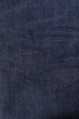 An image of close-up blue denim jeans fabric showing detailed texture with a dark blue color and a stylish design backdrop